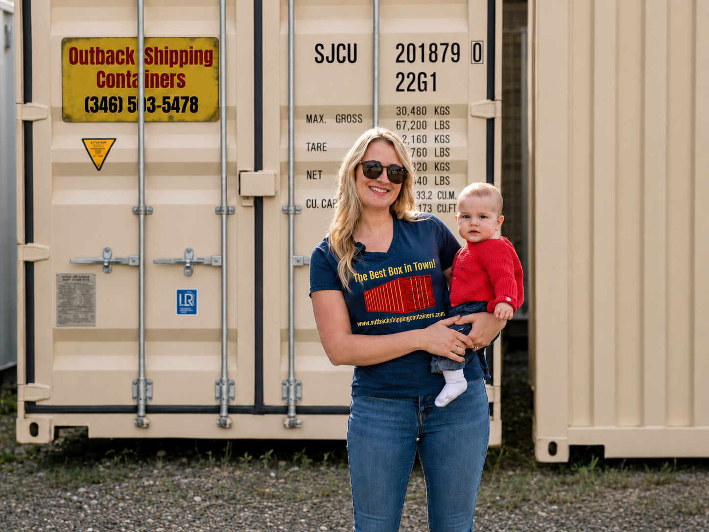 Sheridan Containers team member holding her child in front of a branded shipping container in Sheridan, WY
